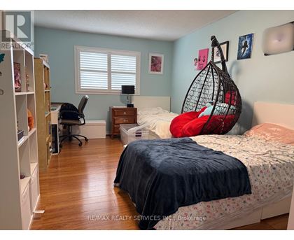 A bedroom with a bed, desk, and chair.