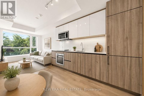 A modern kitchen with wooden cabinets and a large window.