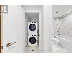 A white bathroom with a washer and dryer in a small space.