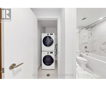 A white bathroom with a washer and dryer in a small space.