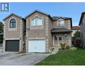 A brick house with a garage door is for sale.