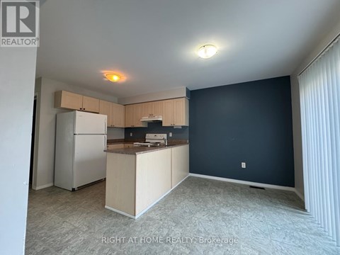 A kitchen area with a refrigerator, microwave, and oven.