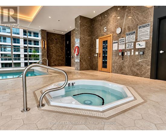 A hot tub in a room with a caution sign on the wall.