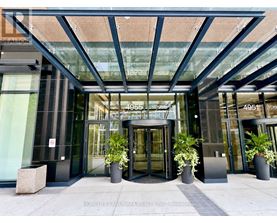 The front of a building with a glass entrance and a sign that reads 4951.