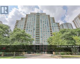 A tall building with many windows is surrounded by trees and has a sign that reads "238 Doris Ave #2009 North York".