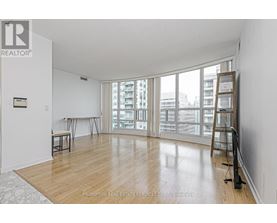 A room with a wooden floor and a ladder leaning against the wall.
