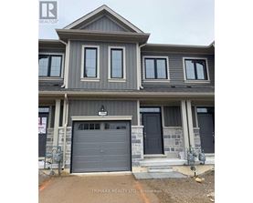A modern house with a grey garage door is for sale.