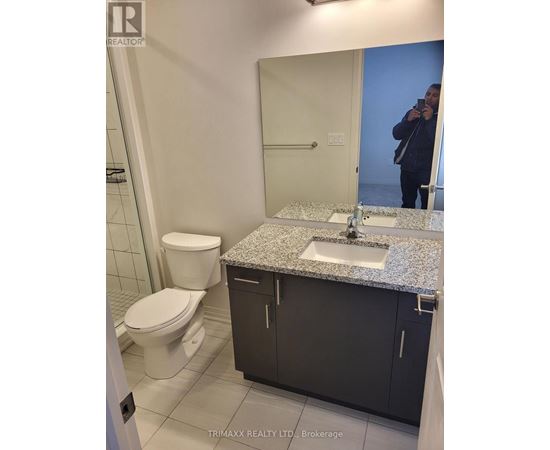 A bathroom with a sink, toilet and mirror.