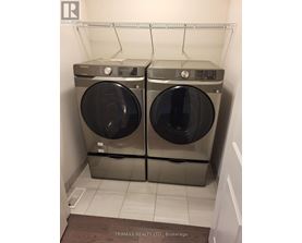 Two front loading washing machines in a small laundry room.