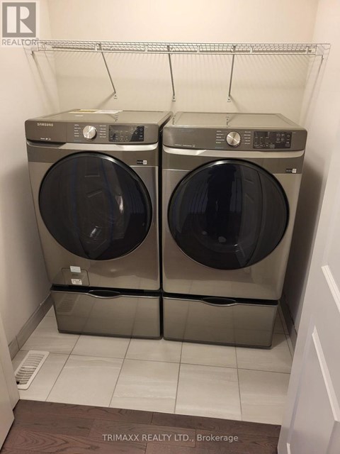 Two front loading washing machines in a small laundry room.