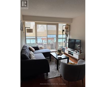 A living room with a couch, chair, and television.