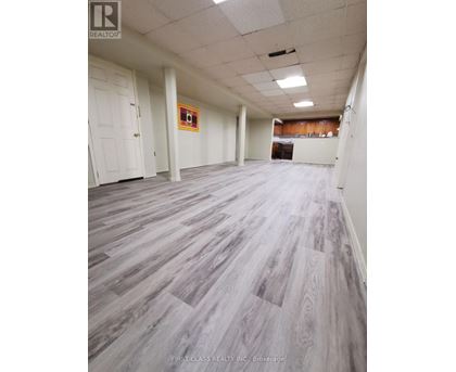 A room with wooden flooring and white walls.