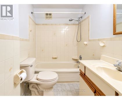 A white toilet is next to a bathtub in a bathroom.