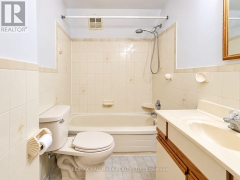 A white toilet is next to a bathtub in a bathroom.