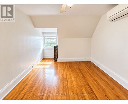 A room with wooden floors and a window with curtains.