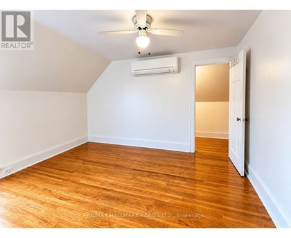 A room with a ceiling fan and wooden flooring.