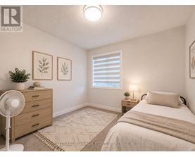 A bedroom with a bed, nightstand, and a fan.