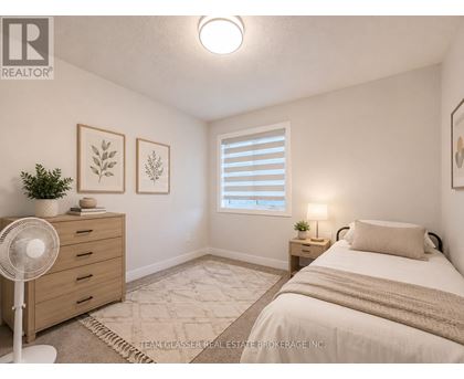 A bedroom with a bed, nightstand, and a fan.
