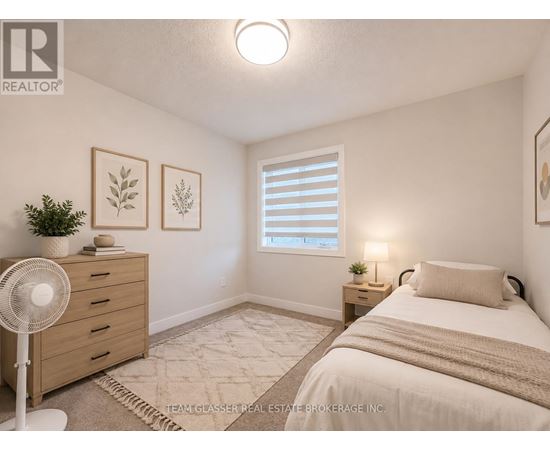 A bedroom with a bed, nightstand, and a fan.