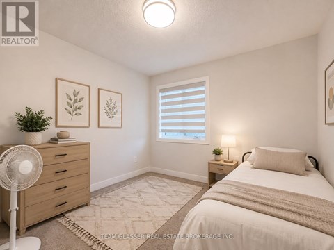 A bedroom with a bed, nightstand, and a fan.
