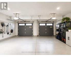 A spacious garage with two doors and a wall of shelves on the right.