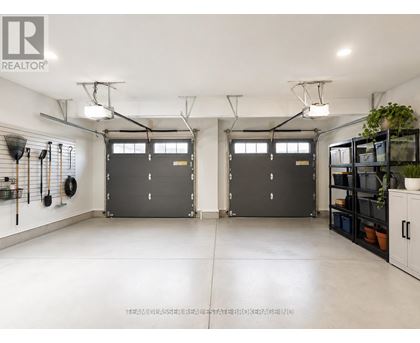 A spacious garage with two doors and a wall of shelves on the right.