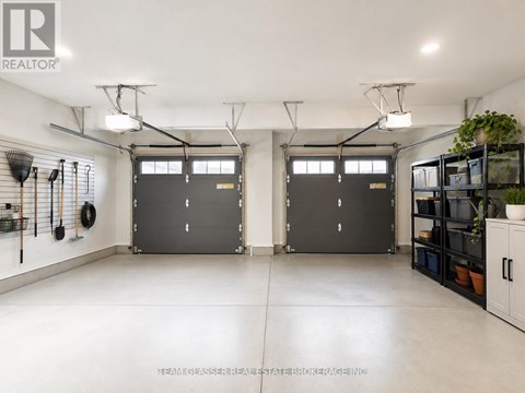 A spacious garage with two doors and a wall of shelves on the right.