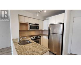 A kitchen with a sink, microwave, and refrigerator.