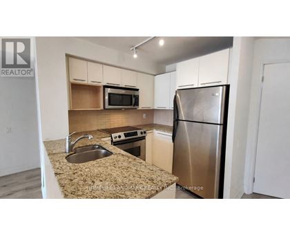 A kitchen with a sink, microwave, and refrigerator.