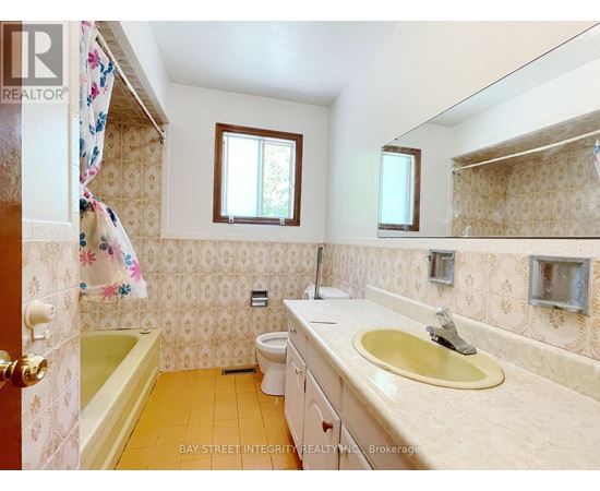 A small bathroom with a toilet, sink, and bathtub.