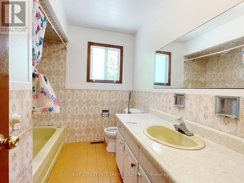 A small bathroom with a toilet, sink, and bathtub.