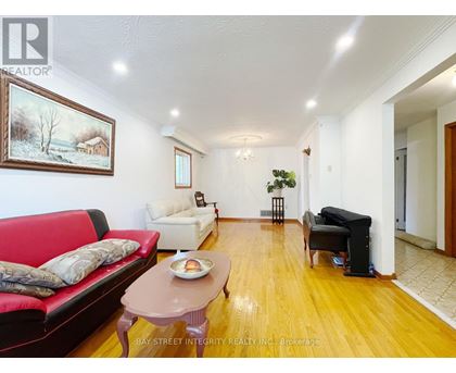 A living room with a red couch, a coffee table, and a painting on the wall.