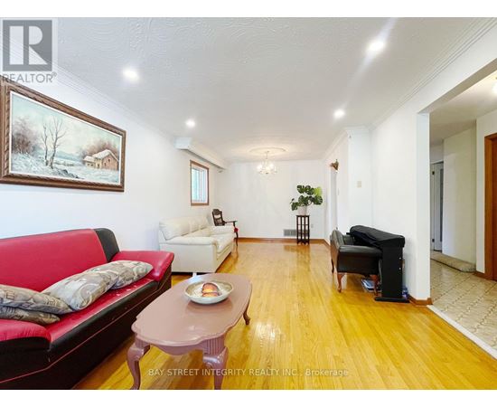 A living room with a red couch, a coffee table, and a painting on the wall.