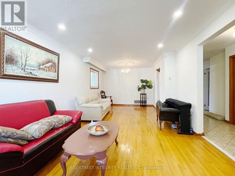 A living room with a red couch, a coffee table, and a painting on the wall.