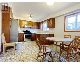 A kitchen with a table and chairs.