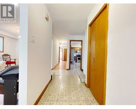 A hallway with a tiled floor and a wooden door.