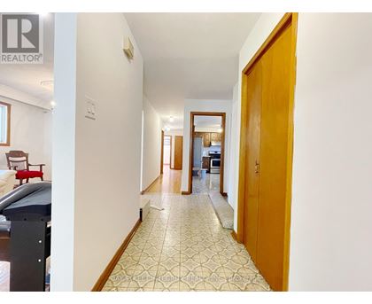 A hallway with a tiled floor and a wooden door.