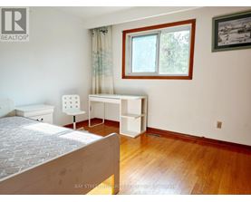 A bedroom with a bed, desk, and chair.