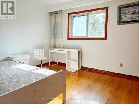 A bedroom with a bed, desk, and chair.
