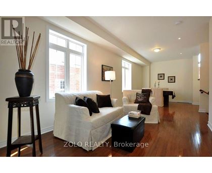 A living room with a white couch and a black table.