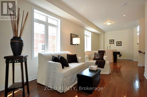 A living room with a white couch and a black table.