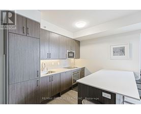 A bedroom with a large bed and a small nightstand.
