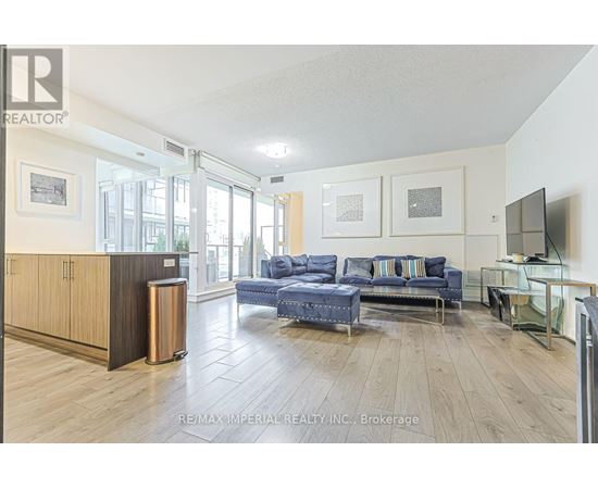 A spacious living room with a blue couch and a television.
