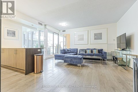 A spacious living room with a blue couch and a television.