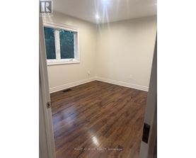 A room with wooden flooring and a window.