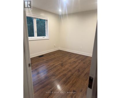 A room with wooden flooring and a window.