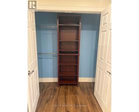 A brown bookcase in a room with blue walls.
