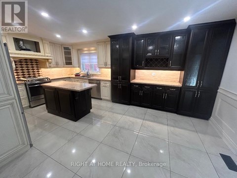 A kitchen with black cabinets and a marble floor.