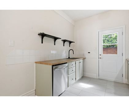 A kitchen with white cabinets and a dishwasher.