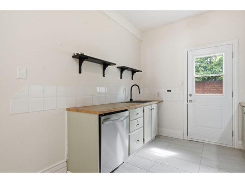 A kitchen with white cabinets and a dishwasher.